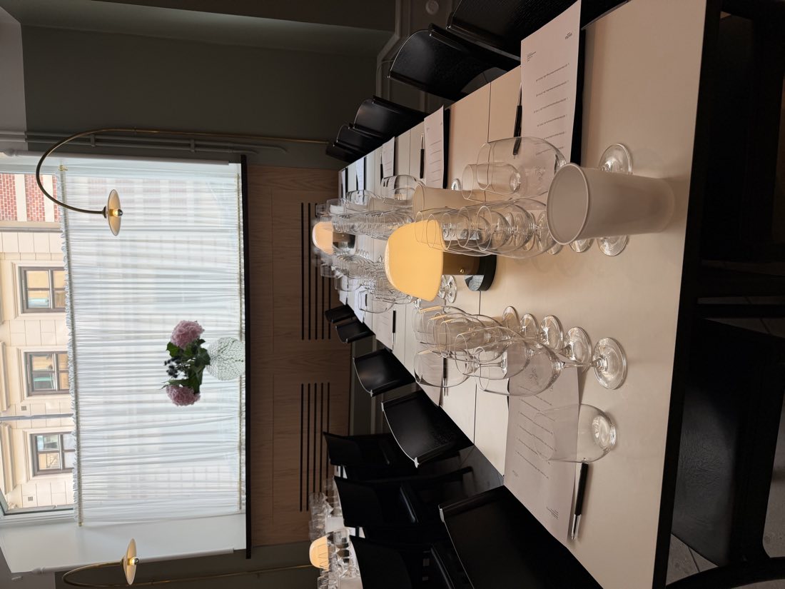 Långbordet dukat med provningsglas och hortensior i fönstret